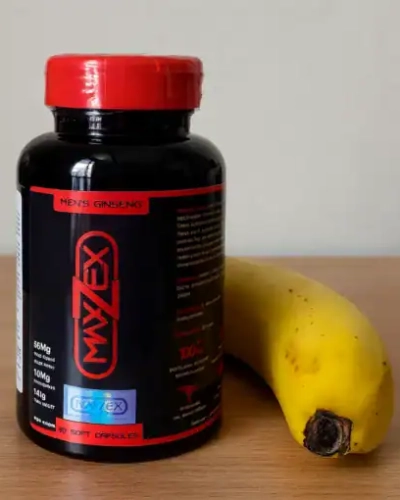 Viên uống Maxzex Nga tăng kích thước dương vật – Chai Maxzex đen cạnh quả chuối trên bàn gỗ