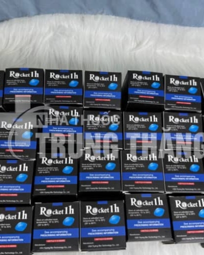 Viên uống Rocket 1h USA hỗ trợ cương cứng – nhiều hộp đen xanh Rocket 1h xếp kín nền lông trắng