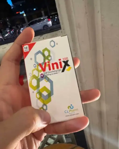 Tem ngậm Vinix 100mg Hàn Quốc chính hãng – tay cầm hộp Vinix 100 trắng đỏ ban đêm ngoài phố